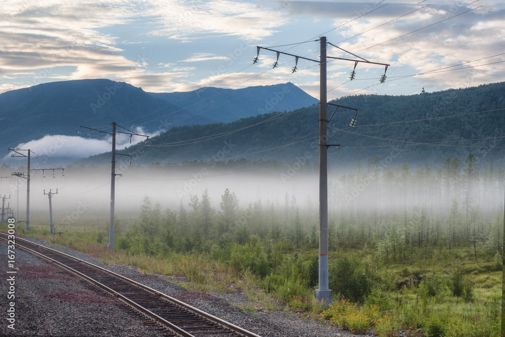 railway in the mountains, fog at dawn