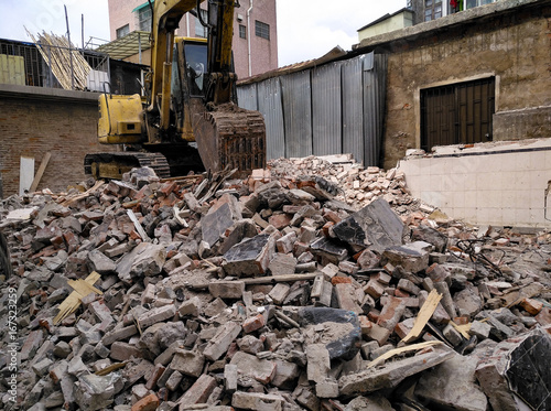 demolished concrete and brick rubble debris with excavator