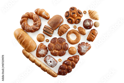 Top view studio shot of a heart shaped collection of different delicious freshly baked loafs of bread isolated on white food love nutrition healthy concept. 