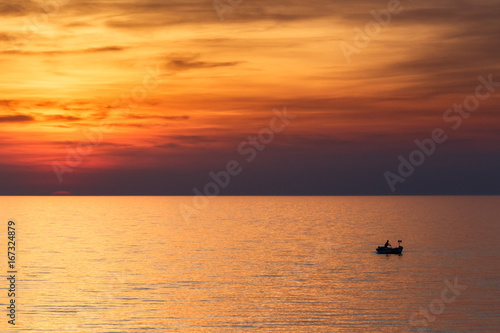 A fisherman sailing on the sea in a boat at a beautiful sunset  Croatia  Europe.