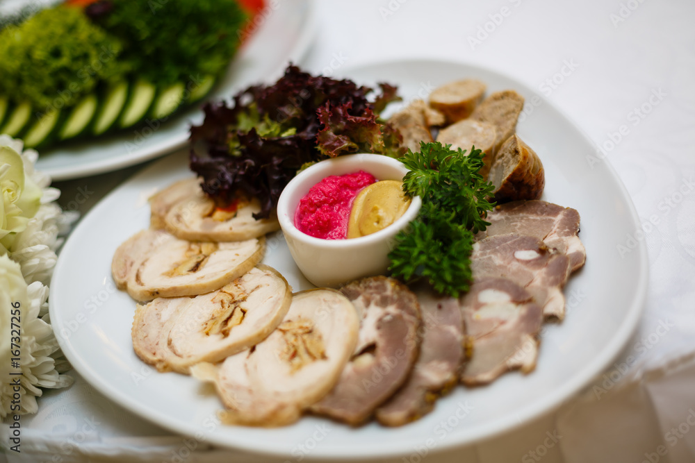 Dish with sliced meat products on the festive table Dish with sliced meat products on the festive table