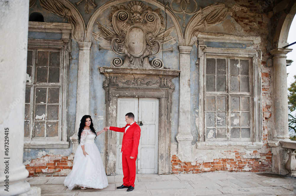Lovely newlyweds dancing outdoor with an outstanding view of an old building with columns.