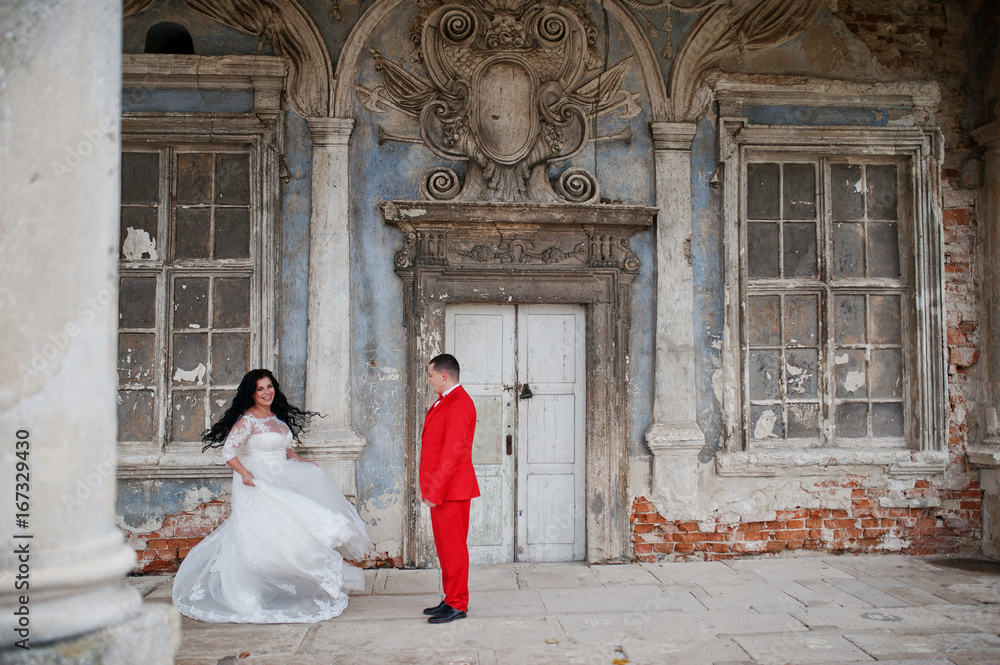 Lovely newlyweds dancing outdoor with an outstanding view of an old building with columns.