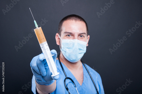 Selective focus of medic wearing scrubs showing syringe