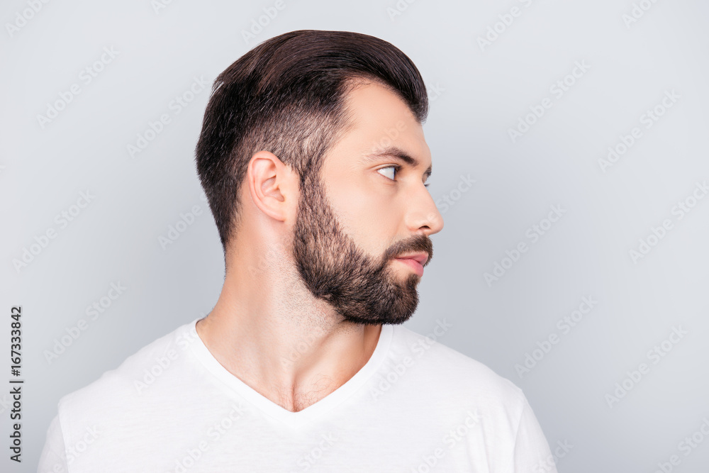 Obraz premium Advertising barbershop concept. Profile side portrait of handsome brunet bearded young man. He has a perfect stunning hair cut, in white t shirt isolated on light grey backgroung
