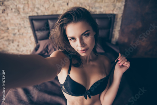 Close up of sexy naughty young brunette lady making selfie in bed, in seductive nice silk bra, waiting for her lover, so hot, gorgeous and seductive, tempting and provocating photo