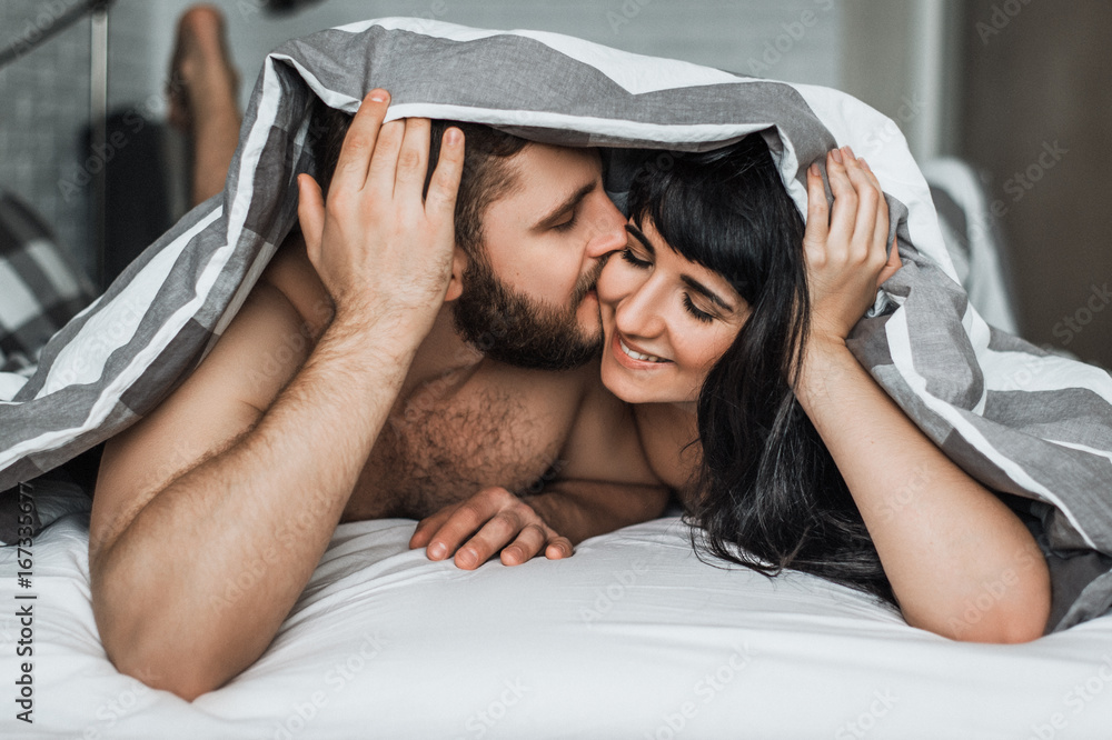 1000px x 666px - Loving couple in bed having sex. Guy and girl kissing in bed. Wedding night.  Make love.