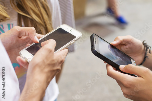 group of young people with mobile phones on the street