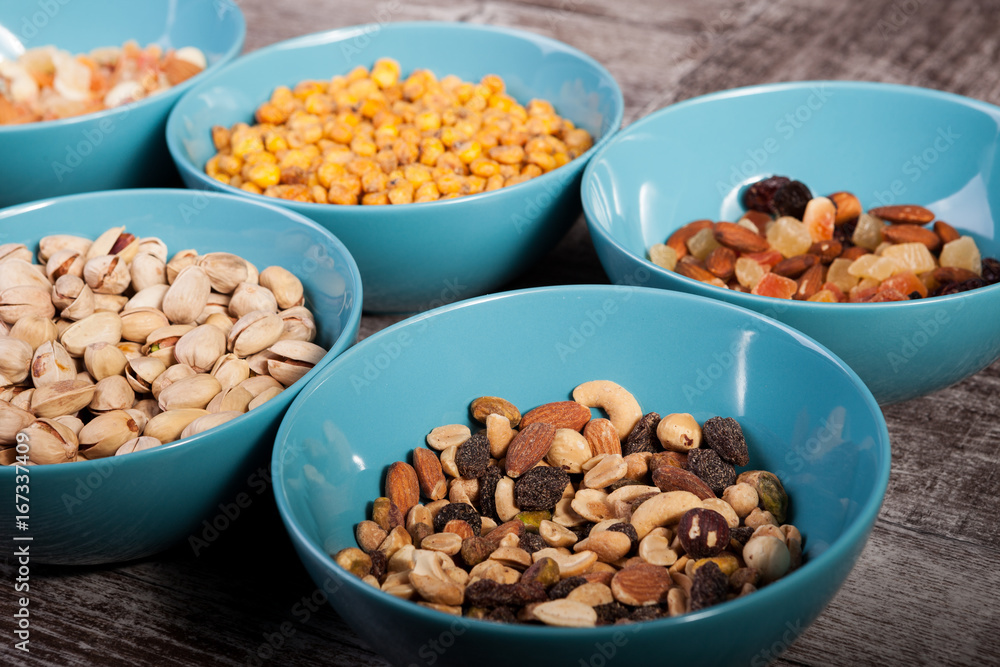 Mix of nuts in bowls on wooden background Mix of nuts in bowls on wooden background