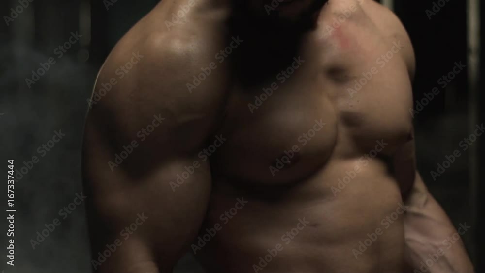 Closeup of Muscular Sporty Man with Naked Torso Working Out With Barbell in Gym