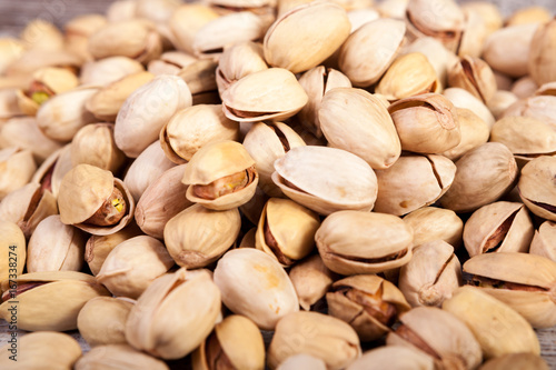 Close up of Pistachios on wooden background in studio photo. Healthy delicious snacks