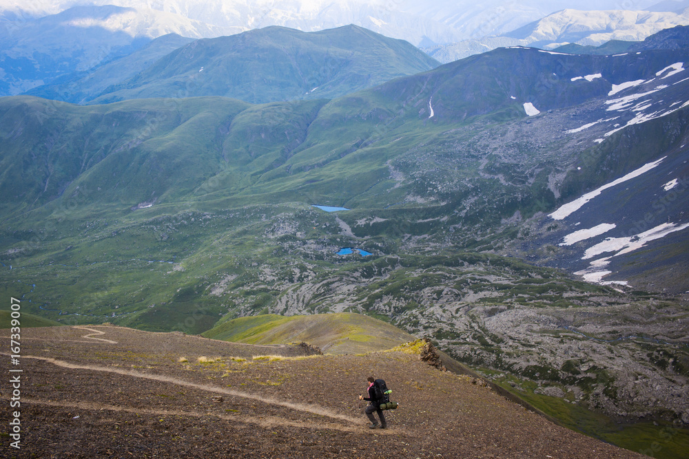 Obraz premium Man with his backpack hiking in the Greater Caucasus mountains, Chaukhi pass, Georgia.