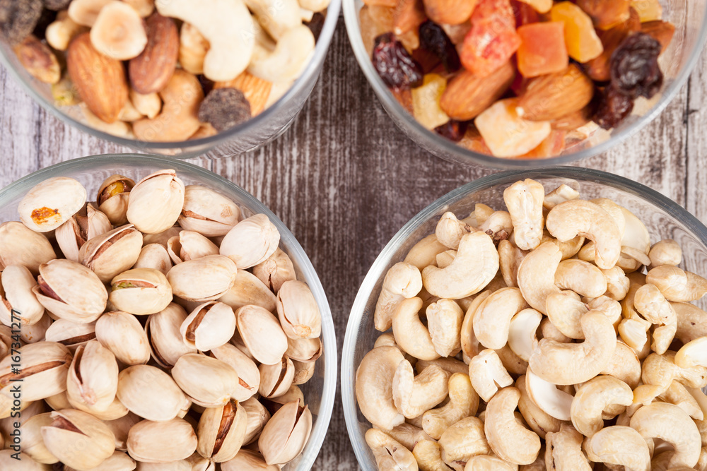 Healthy mix of dried nuts and sweets in was glass on wooden background in studio photo Healthy mix of dried nuts and sweets in was glass on wooden background in studio photo