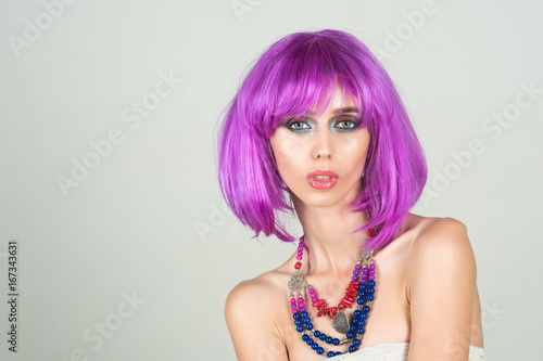 Girl with bright artificial hair in ethnic jewelry.