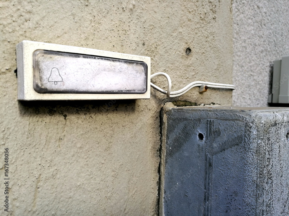 Alte Klingel mit weißer Fläche ohne Namen an einem alten Haus in Beige