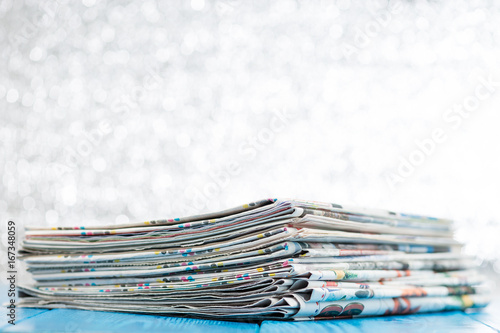 selective focus on stack of newspapers on wooden background
