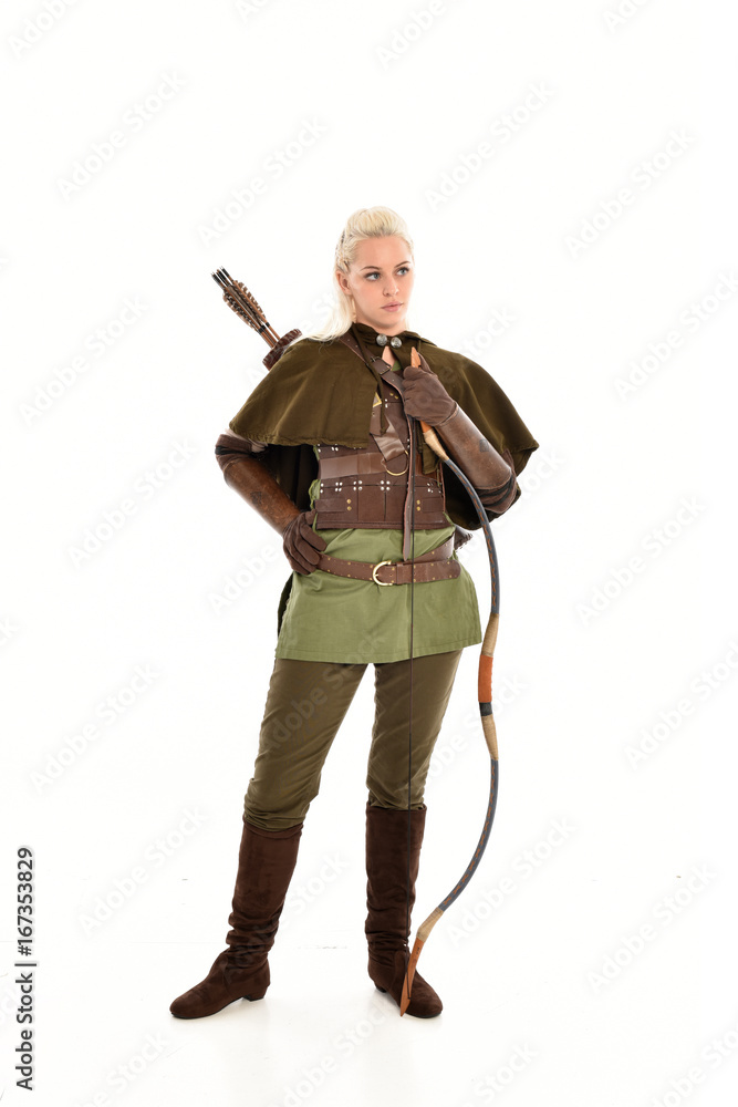 full length portrait of a blonde girl wearing green and brown medieval costume, holding a bow and arrow. isolated on white background. full length portrait of a blonde girl wearing green and brown medieval costume, holding a bow and arrow. isolated on white background.