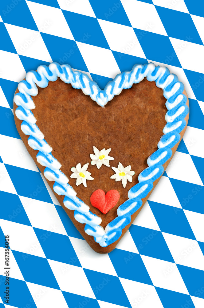Obraz premium Oktoberfest Gingerbread heart with copy space on bavarian white blue flag.