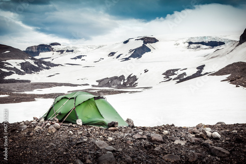 Camping with tent. Snowy mountain glaciers and storm wind. Iceland photo