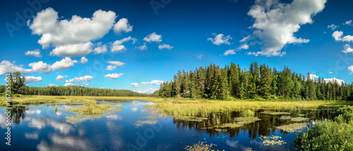 Fototapeta Naklejka Na Ścianę i Meble -  Blue mirror lake reflections of clouds and landscape. Ontario, Canada.