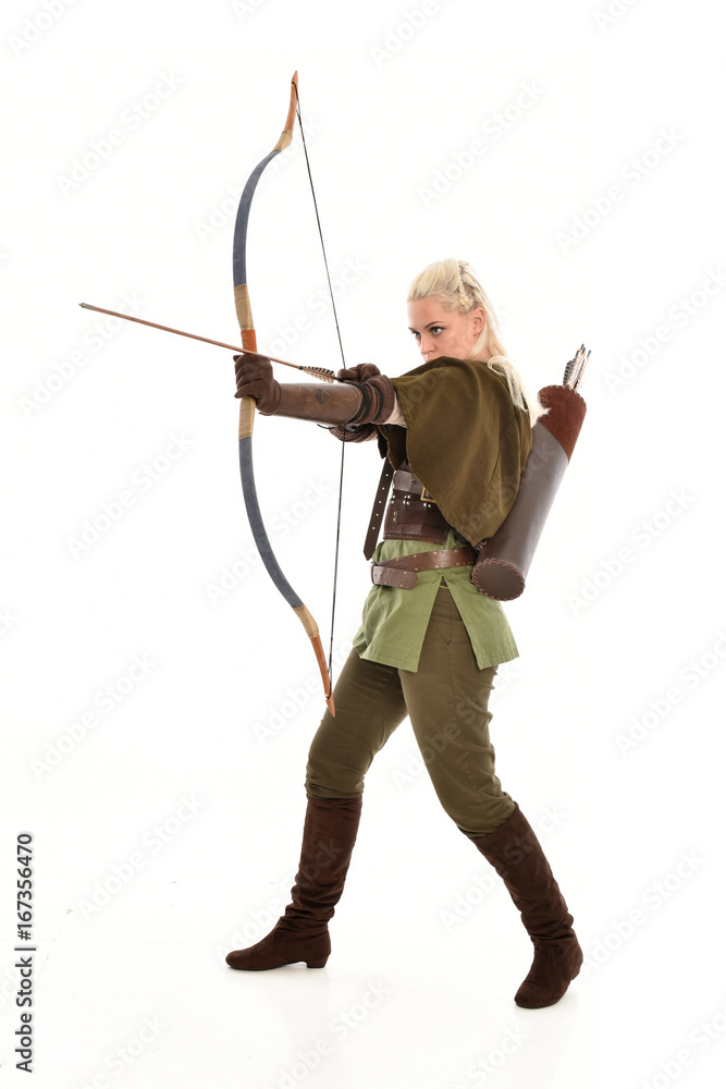 full length portrait of a blonde girl wearing green and brown medieval costume, holding a bow and arrow. isolated on white background. full length portrait of a blonde girl wearing green and brown medieval costume, holding a bow and arrow. isolated on white background.