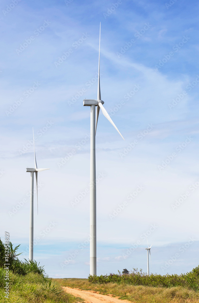 white wind turbines generating electricity in wind power station under blue sky background        