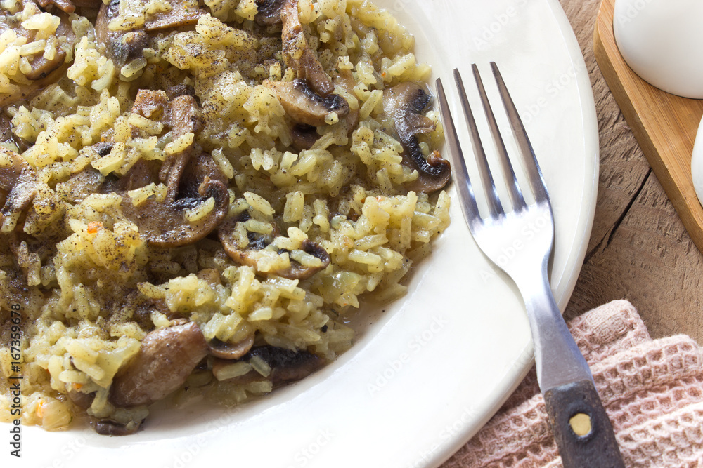 Risotto with mushrooms on plate with fork Risotto with mushrooms on plate with fork