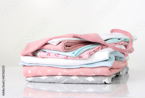 Soft color stack pile of clothes on white.
