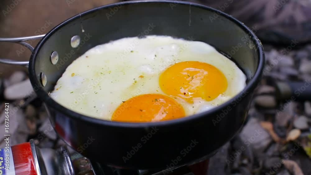 Scrambled eggs fried in a pan on a camp stoves Scrambled eggs fried in a pan on a camp stoves