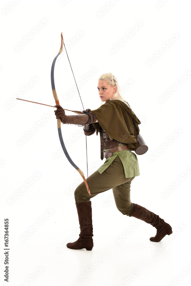 full length portrait of a blonde girl wearing green and brown medieval costume, holding a bow and arrow. isolated on white background. full length portrait of a blonde girl wearing green and brown medieval costume, holding a bow and arrow. isolated on white background.