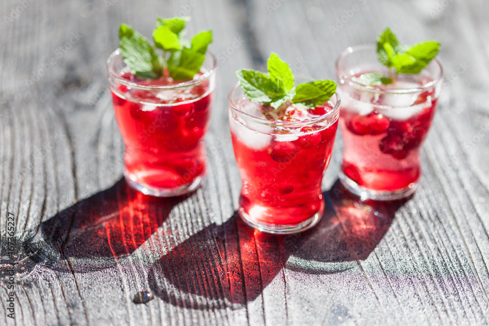 Cranberry drinks with mint on dark rustic wooden background, selective focus Cranberry drinks with mint on dark rustic wooden background, selective focus