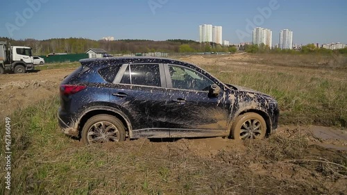 SUV car stuck in the mud trying to get out.