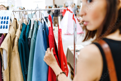 Young woman looking aside while shopping clothes photo