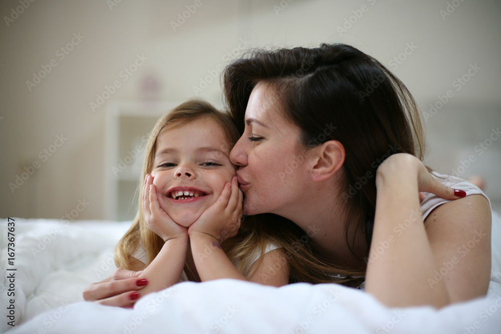 Mother with her cute little daughter lying on bed. Mother with her cute little daughter lying on bed.