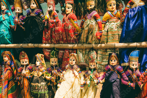 Indian market showcase with funny handmade dolls in traditional costumes. Marketplace with old style toys for children in India