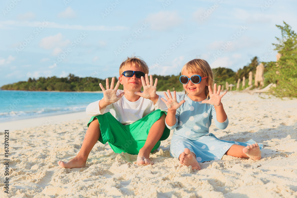 happy little boy and girl play on summer beach happy little boy and girl play on summer beach