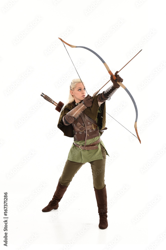 full length portrait of a blonde girl wearing green and brown medieval costume, holding a bow and arrow. isolated on white background. full length portrait of a blonde girl wearing green and brown medieval costume, holding a bow and arrow. isolated on white background.