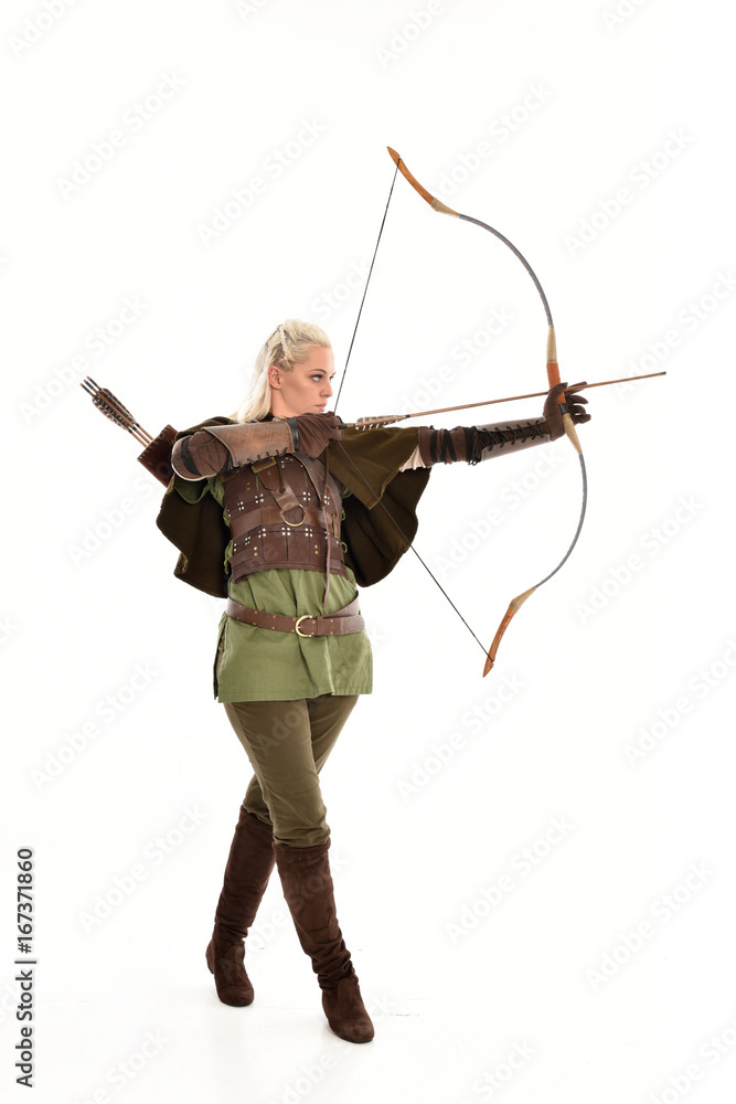 full length portrait of a blonde girl wearing green and brown medieval costume, holding a bow and arrow. isolated on white background. full length portrait of a blonde girl wearing green and brown medieval costume, holding a bow and arrow. isolated on white background.