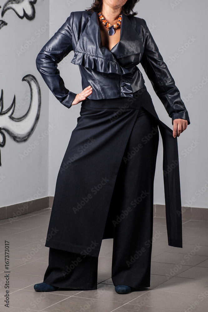 Beautiful woman posing in black leather jacket, pants and skirt. Details of women's clothing. Beautiful woman posing in black leather jacket, pants and skirt. Details of women's clothing.