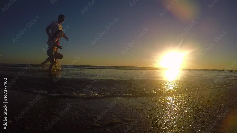 Father and daughter playing on the beach at the day sunset. Concept of friendly family. Father and daughter playing on the beach at the day sunset. Concept of friendly family.