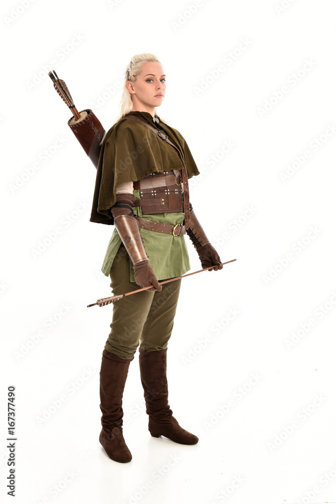 full length portrait of a blonde girl wearing green and brown medieval costume, holding a bow and arrow. isolated on white background. full length portrait of a blonde girl wearing green and brown medieval costume, holding a bow and arrow. isolated on white background.