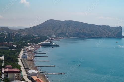 View of the seaside town Sudak in Crimea with coast, pier and sea