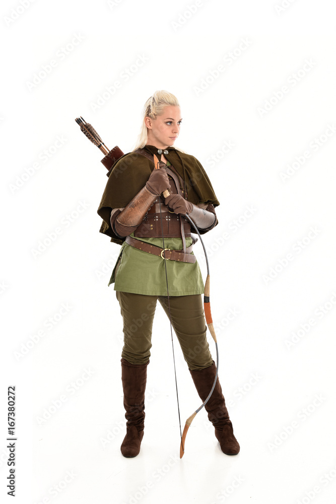 full length portrait of a blonde girl wearing green and brown medieval costume, holding a bow and arrow. isolated on white background. full length portrait of a blonde girl wearing green and brown medieval costume, holding a bow and arrow. isolated on white background.
