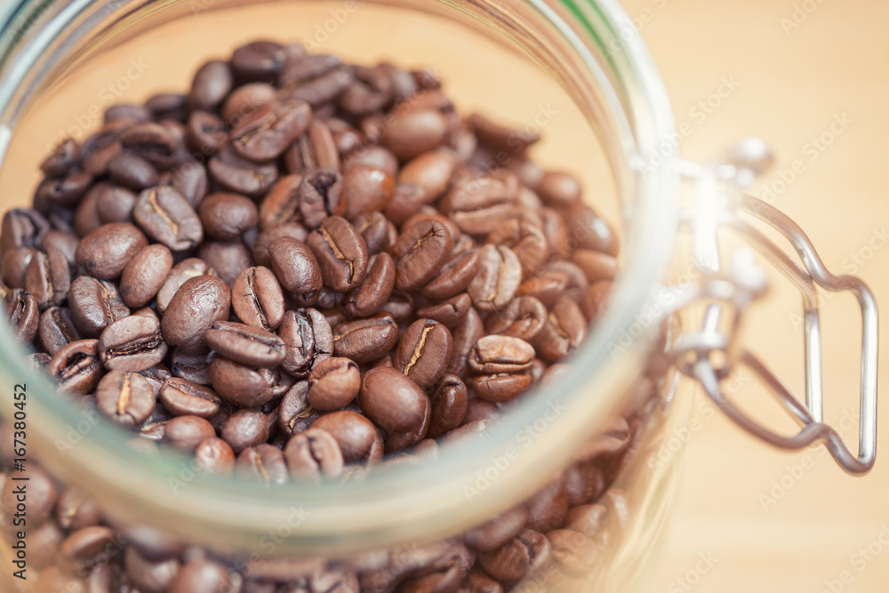 Fototapeta premium Coffee beans in glass jar. Shallow dof