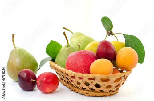 Fruit composition - wicker wooden basket with whole ripe fruit on a white background