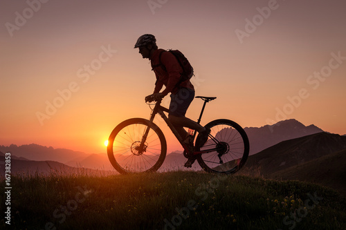 Silhouette of a male mountainbiker at sunset in the mountains