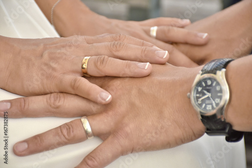 hands of freshly married couple holding each other
