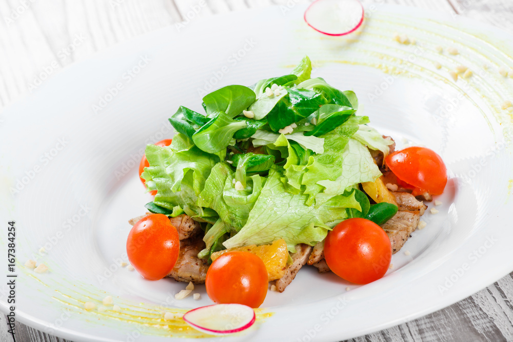 Fresh salad with chicken breast, baby spinach, lettuce, cherry tomatoes and cheese on wooden background close up Fresh salad with chicken breast, baby spinach, lettuce, cherry tomatoes and cheese on wooden background close up
