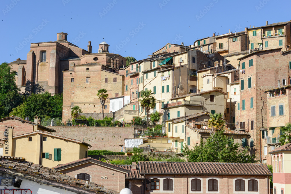 Ancient houses on the slope of the mountain at old Siena on Italy