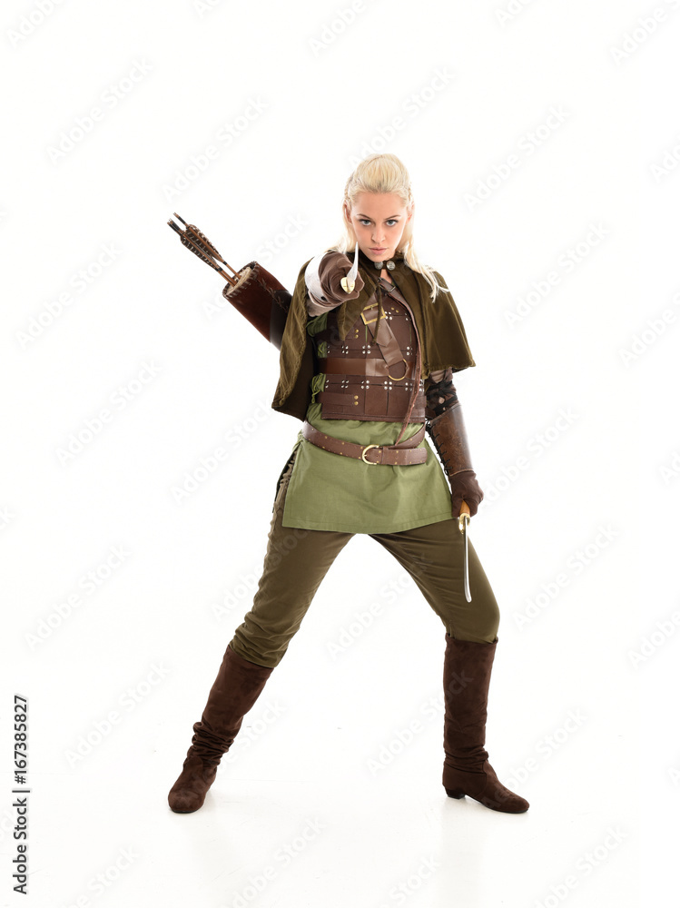 full length portrait of a blonde girl wearing green and brown medieval costume, holding a bow and arrow. isolated on white background. full length portrait of a blonde girl wearing green and brown medieval costume, holding a bow and arrow. isolated on white background.